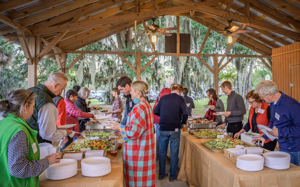 Guests fill their plates at the Oyster Roast for a Reason buffet.