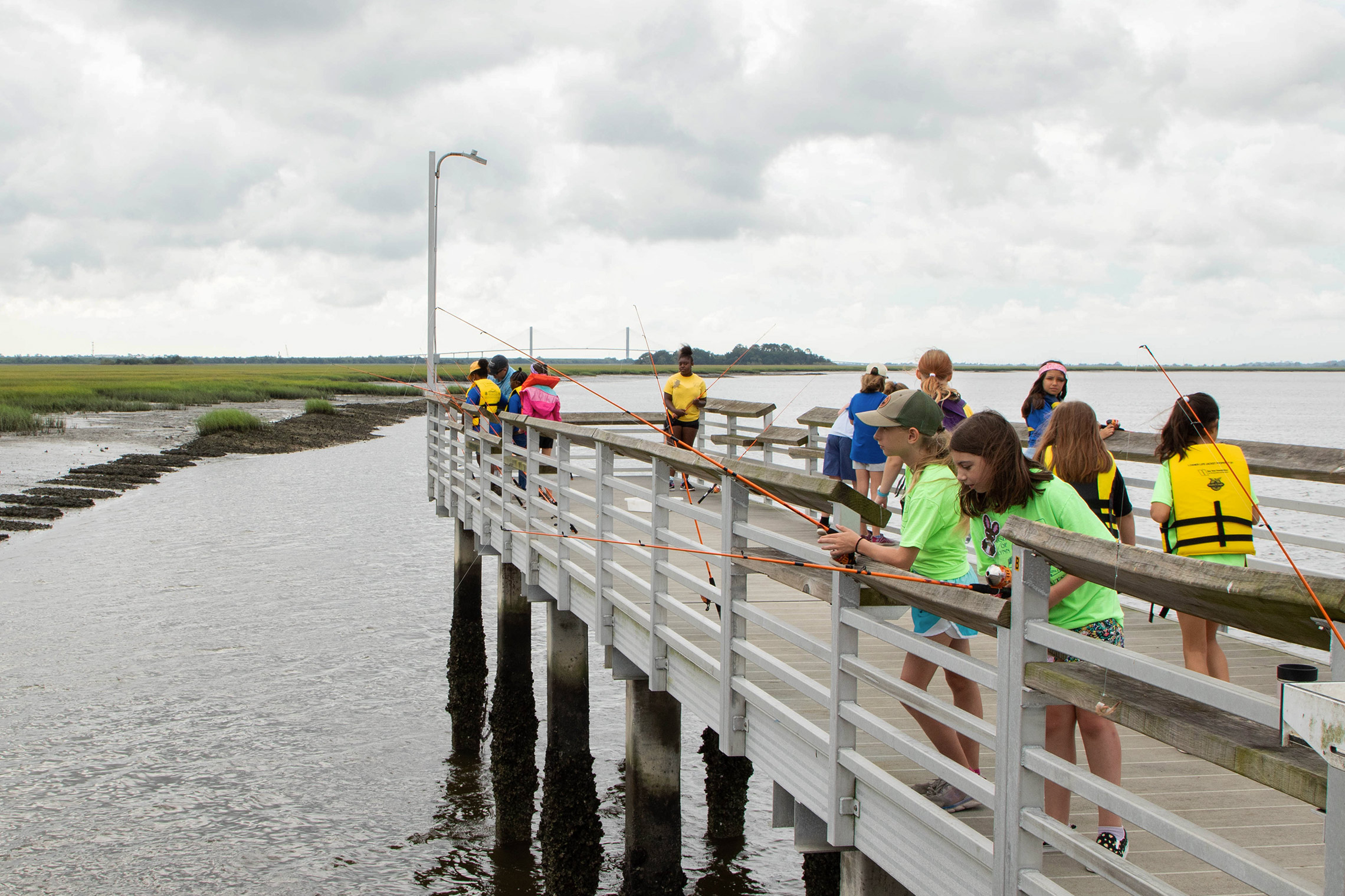 A group of kids recreationally fishing off of a dock in Brunswick, GA