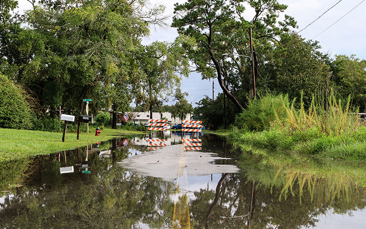 a flooded roadway with hazard barricades