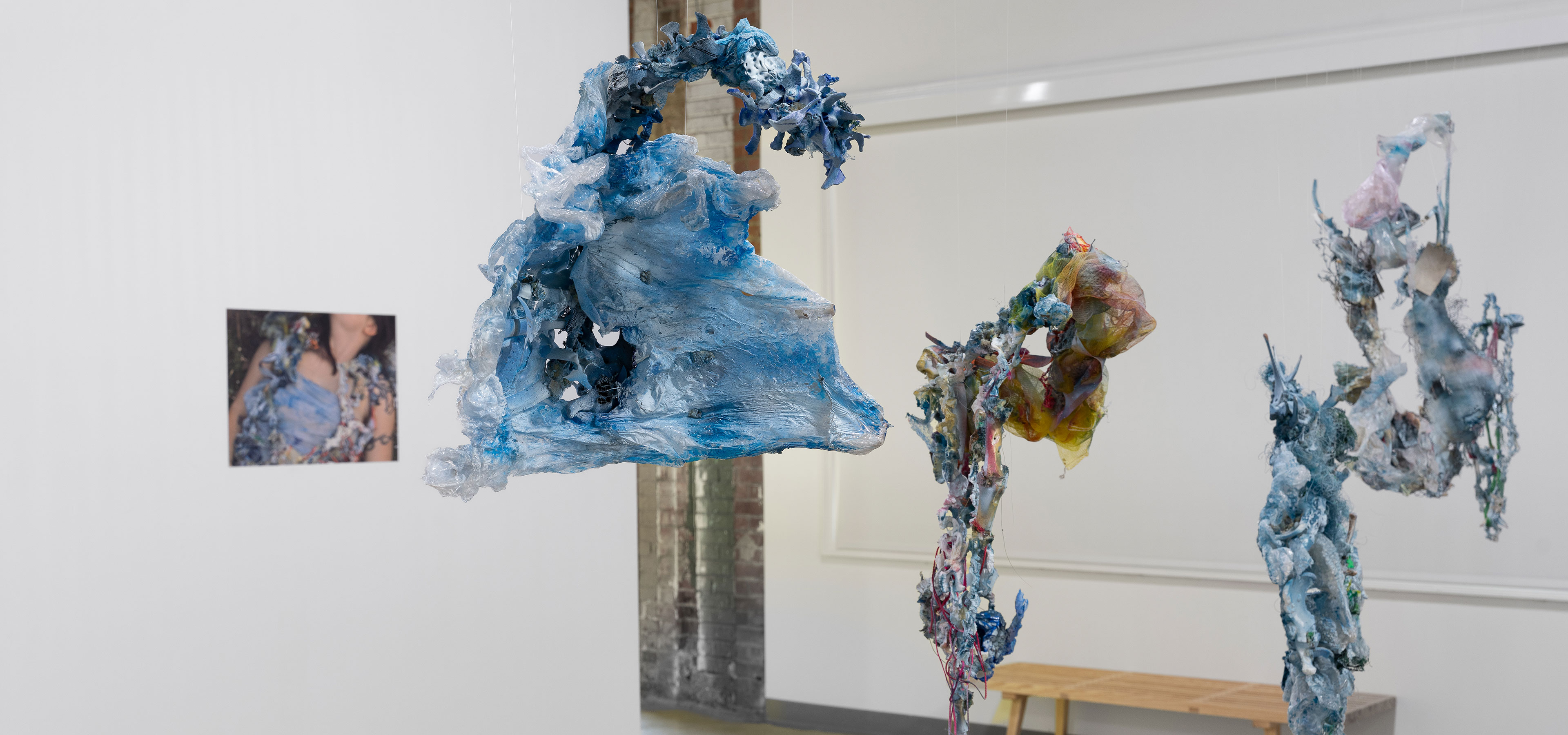 abstract blue shapes hang from a ceiling in an art exhibit